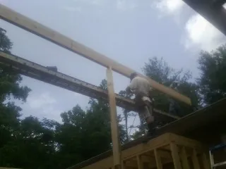 Carpenter setting a ridge beam over a new addition frame — Ice Dam Removal by Roofing Brothers in Pulteney