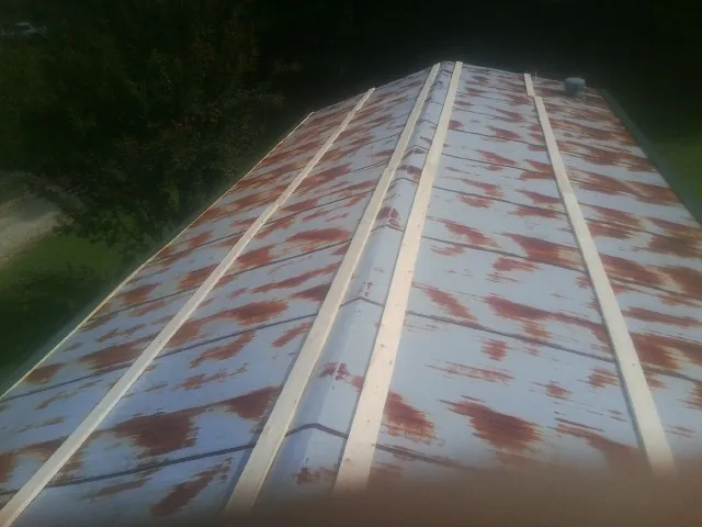 Rusted metal roof panels with new wood purlins before replacement — Storm Damage Roof Repair in Pulteney by Roofing Brothers