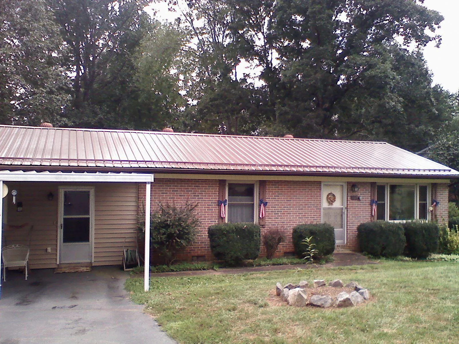 Bronze metal roof and carport on a brick ranch home — Roof Repair work by our crew in Pulteney